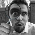person looking through magnifying glass