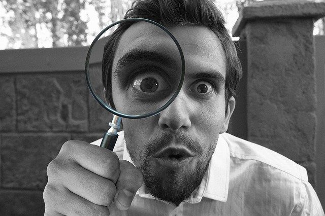 person looking through magnifying glass