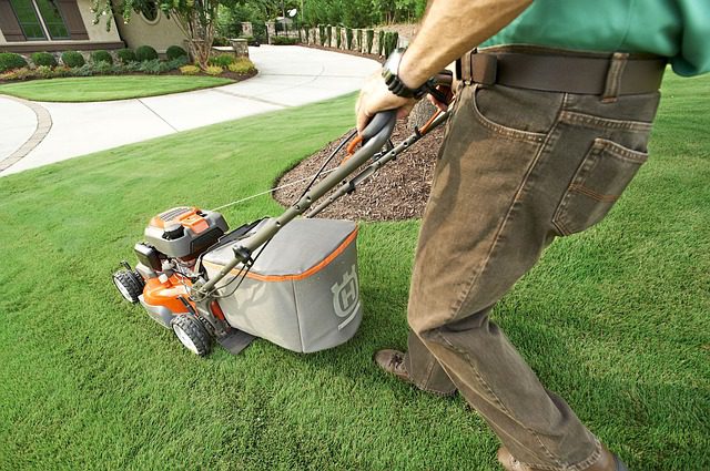 lawncare employee mowing a lawn